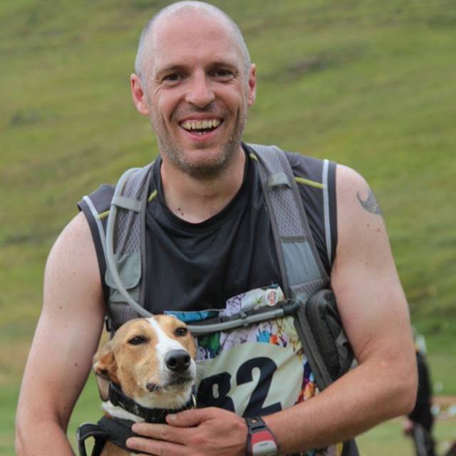 Mike smiling and holding his dog at an event